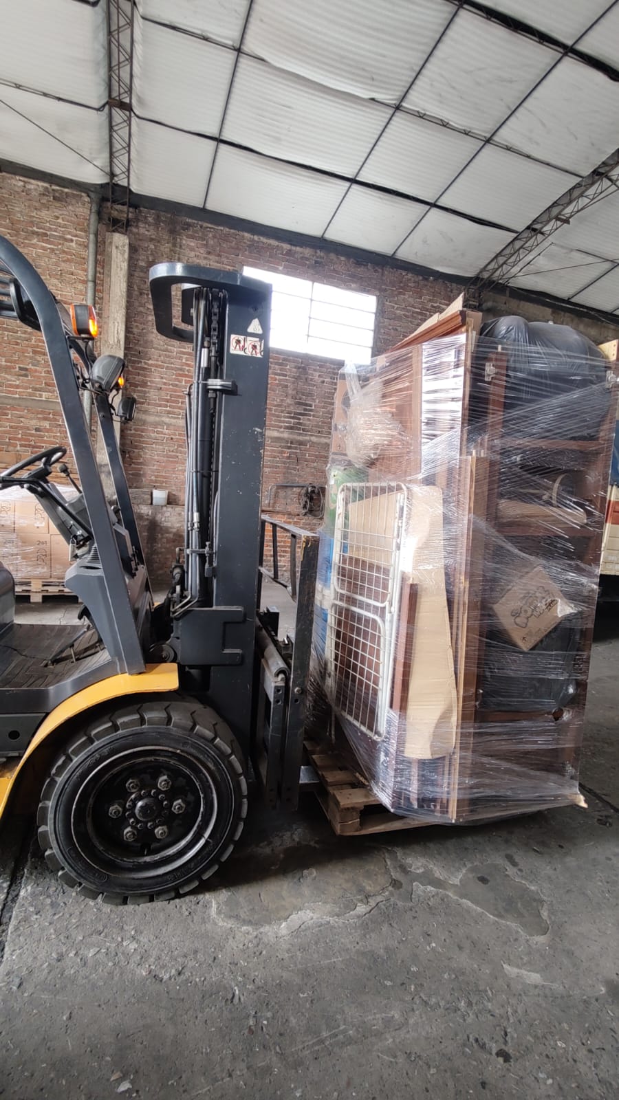 Autoelevador de Transporte PETI moviendo un pallet con bienes embalados